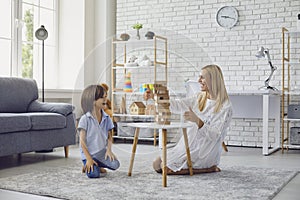 Mother and child have fun playing board games at home.