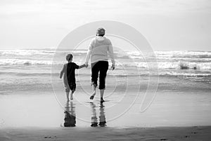 Mother and Child hold hands on beach