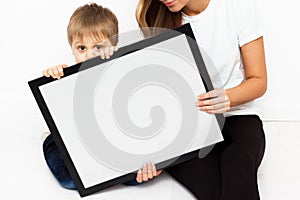 Mother with child holding a frame.