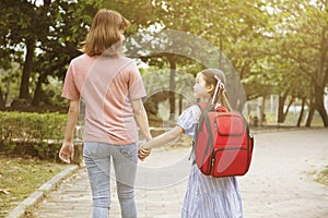 Mother and child holding hands going to school