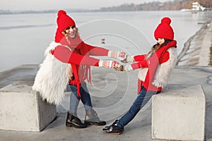 Mother and child in knitted winter hats play in winter park