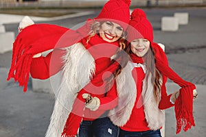 Mother and child in knitted winter hats play in winter park