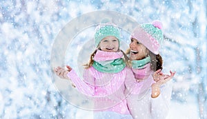 Mother and child in knitted winter hats in snow