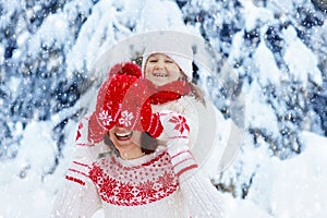 Mother and child in knitted winter hats in snow