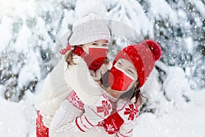 Mother and child in knitted winter hats in snow