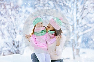 Mother and child in knitted winter hats in snow