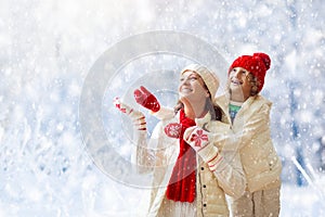 Mother and child in knitted winter hats in snow