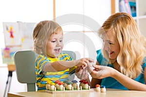 Mother and child learn color, size, count while playing with developmental toys. Early education concept.