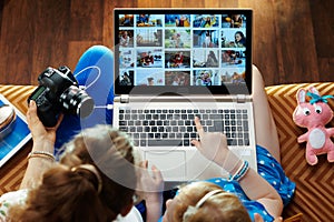 Mother and child looks at photo collage on laptop