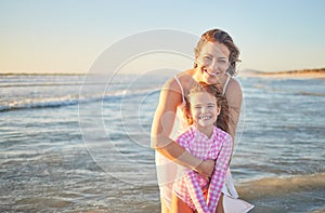 Mother, child and ocean smile in water, happy and fun time together on family vacation by the sea. Woman, girl and beach