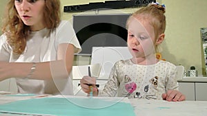 Mother and child paint with colored brush. Games with children affect the development of early children.