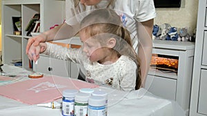 Mother and child paint with colored fingers. Games with children affect the development of early children.