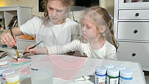 Mother and child paint with colored fingers. Games with children affect the development of early children.