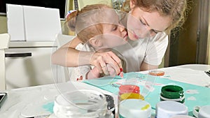 Mother and child paint with colored fingers. Games with children affect the development of early children.