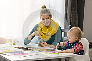 Mother and child painting with watercolors together