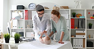 Mother with child at pediatrician reception in white room, checking motility skills of child