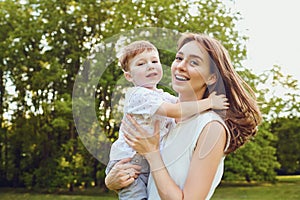 Mother and child play hugging in the park.