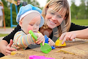 Mother and child play in sandbox