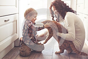 Mother and child playing with cat