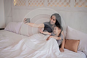 A mother and child are playing cell phones together