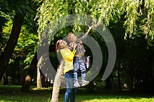 Mother and child playing at summer city park on nature