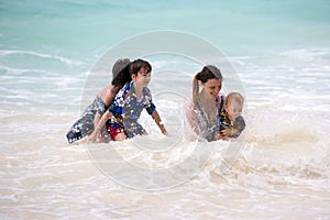 Mother and child playing at tropical beach. Family sea summer vacation. Mom and kid, toddler boy, play in the water. Ocean and