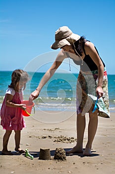 Mother and child plays on the beach