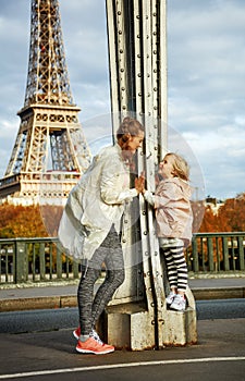 Mother and child on Pont de Bir-Hakeim bridge having fun time