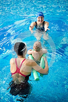 Mother with child in pool. Instructor teaching little child swimming. Prevention of diseases of musculoskeletal system