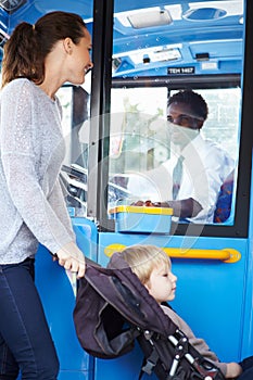 Mother With Child In Pushchair Boarding Bus