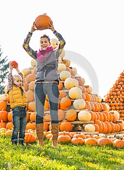 Mother and child rising pumpkin up