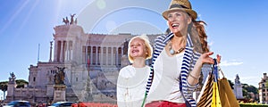 Mother and child with shopping bags looking into distance