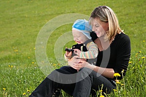 Mother with child sit on grass
