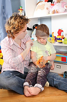 Mother with child sit in playroom