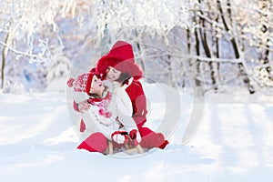 Mother and child sledding. Winter snow fun. Family on sleigh.