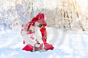 Mother and child sledding. Winter snow fun. Family on sleigh.