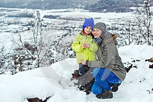 Mother and child on snowy winter walk. Family enjoying beautiful winter nature. Snowy winter season