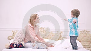 Mother and child son play in bed. Mom and child son talking in bedroom. Mothers day. Motherhood and parenting, happy