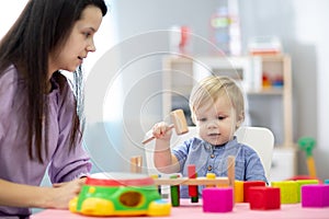 Mother and child son playing with educational toys together at home