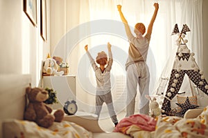 Mother and child stretch themselves after waking up in the morning