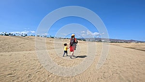 Mother and child on summer vacation in the dunes of Maspalomas, Gran Canaria