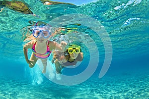 Mother with child swim underwater with fun in sea