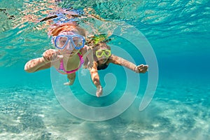 Mother with child swim underwater with fun in sea