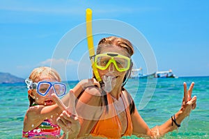 Mother with child swim underwater with fun in sea