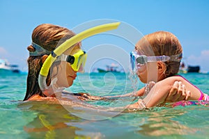 Mother with child swim underwater with fun in sea