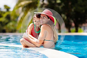 Mother, child at swimming pool. Mom and kid swim