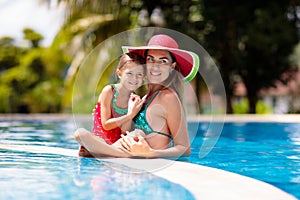 Mother, child at swimming pool. Mom and kid swim