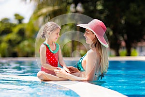 Mother, child at swimming pool. Mom and kid swim