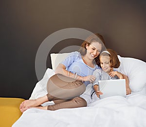 Mother, child and tablet for bed relax in home for funny movie with streaming, laughing or bonding. Woman, daughter and