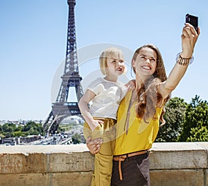 Mother and child taking selfie with digital camera in Paris